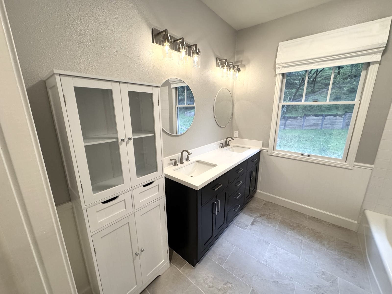 Bathroom remodel in Thousand Oaks with dark double vanity and tile floor